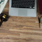 photo of law gavel, legal book and laptop keyboard