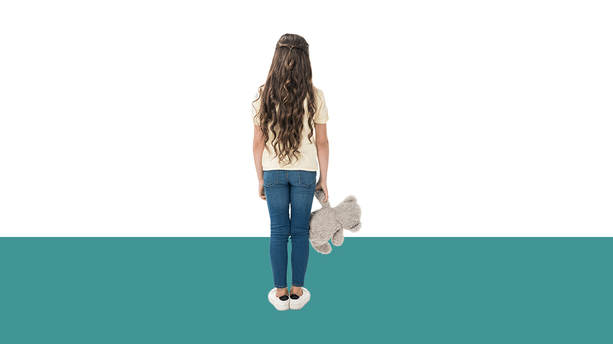 photo of child holding a teddy bear, facing away from camera