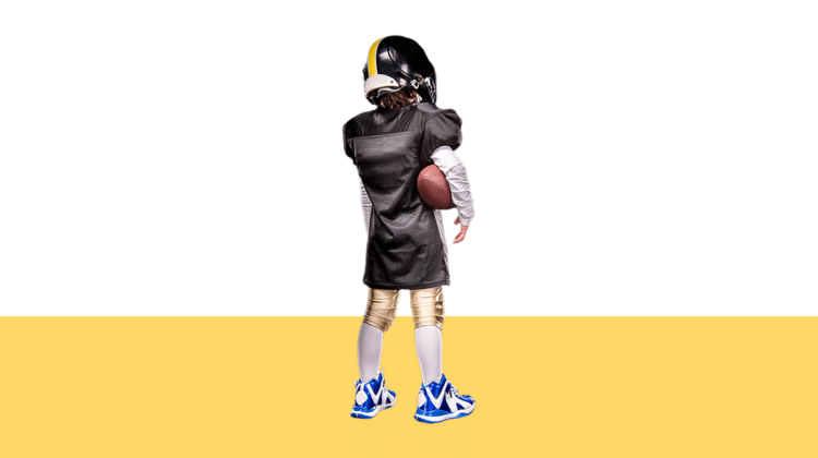 photo of child in football uniform facing away from camera from blog post about when parenting time conflicts with extracurricular activities
