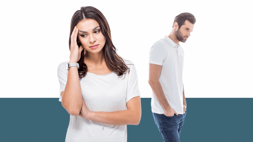 photo of woman holding her head, looking stressed, with man in background, from a blog post asking is emotional abuse domestic violence